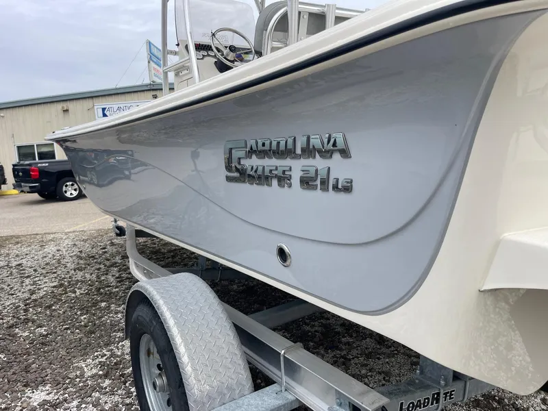 Slide: The Image of 2025 Carolina Skiff 21 LS boat on trailer, side view, parked outdoors. - 3