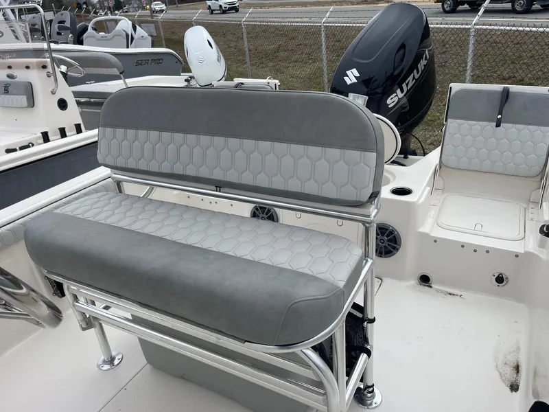 Slide: The Image of 2025 Carolina Skiff 21 LS boat interior with gray seating and Suzuki outboard motor. - 9