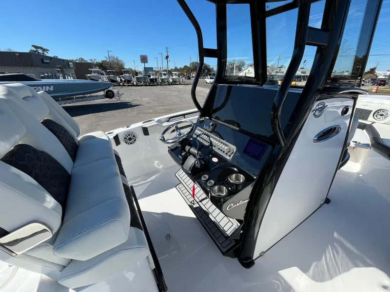 Slide: The Image of 2024 Tidewater 280 CC Adventure boat interior with modern console and seating. - 12