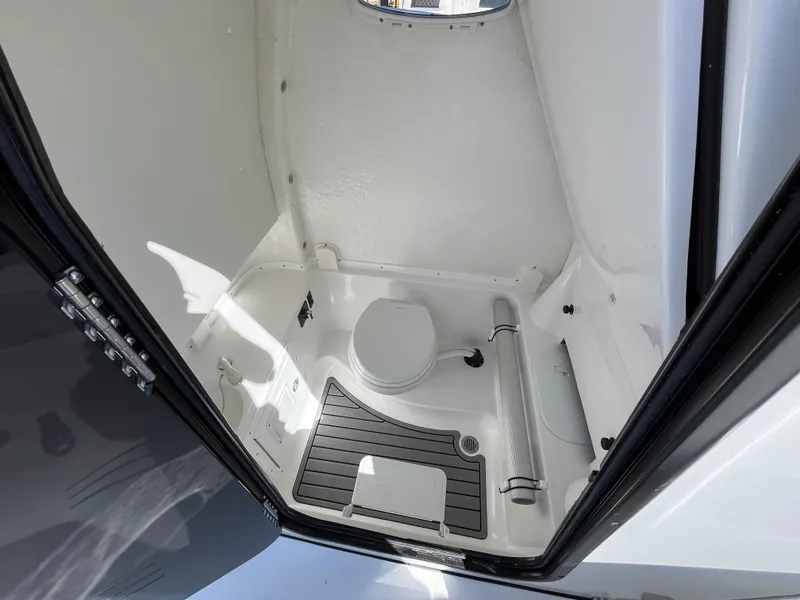 Slide: The Image of 2024 Tidewater 280 CC Adventure boat interior with compact marine toilet. - 16