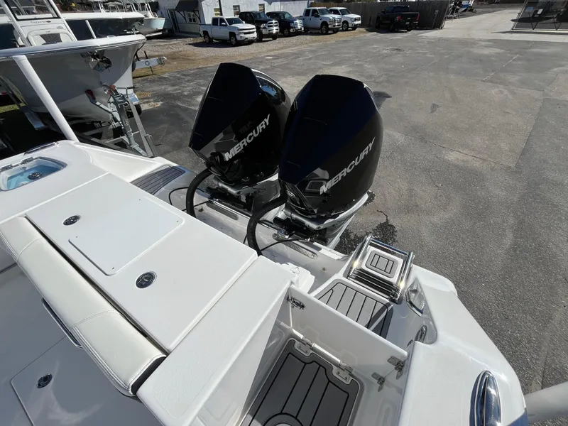 Slide: The Image of 2024 Tidewater 280 CC Adventure with dual Mercury outboard engines, docked in a marina. - 5