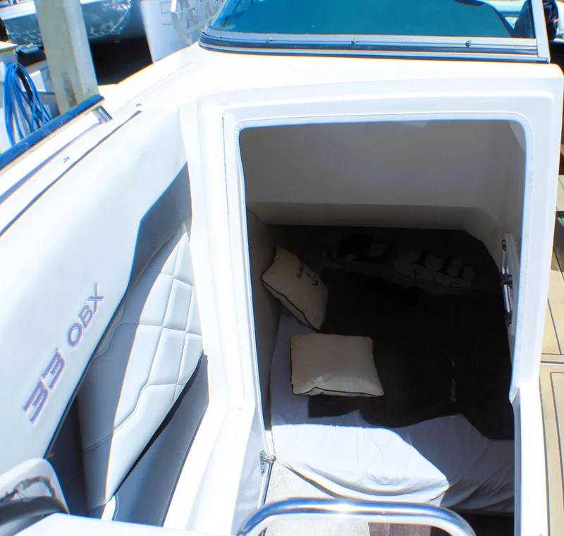 Slide: The Image of 2022 Regal 33 OBX boat cabin interior with cushions and seating. - 11