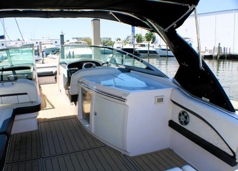 Slide: The Image of 2022 Regal 33 OBX boat interior with sleek design and modern amenities at a marina. - 14