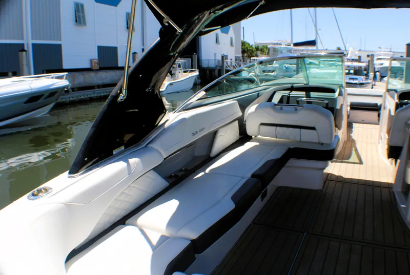 Slide: The Image of 2022 Regal 33 OBX boat with luxurious seating and sleek design at a marina. - 15