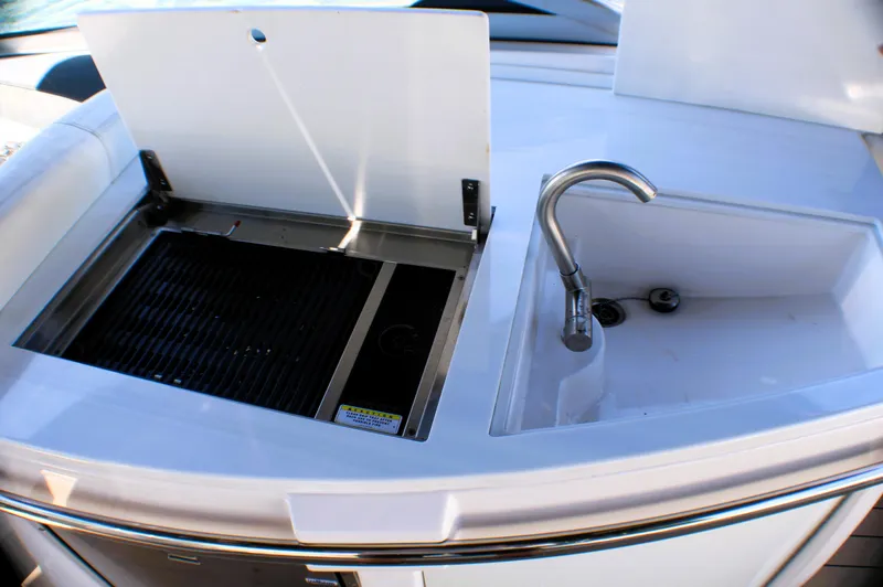 Slide: The Image of 2022 Regal 33 OBX boat kitchenette with sink and grill. - 16