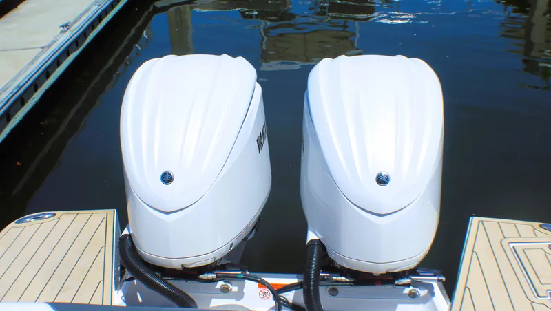 Slide: The Image of Twin outboard engines on a 2022 Regal 33 OBX boat docked by the water. - 22