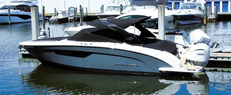 Slide: The Image of 2022 Regal 33 OBX boat docked in marina, featuring sleek design and Yamaha engines. - 25