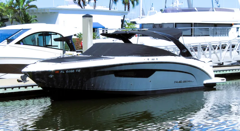 Slide: The Image of 2022 Regal 33 OBX boat docked at marina, sleek design, black and white color scheme. - 26