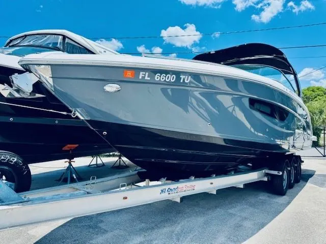 Slide: The Image of 2022 Regal 33 OBX boat on trailer under clear blue sky. - 28