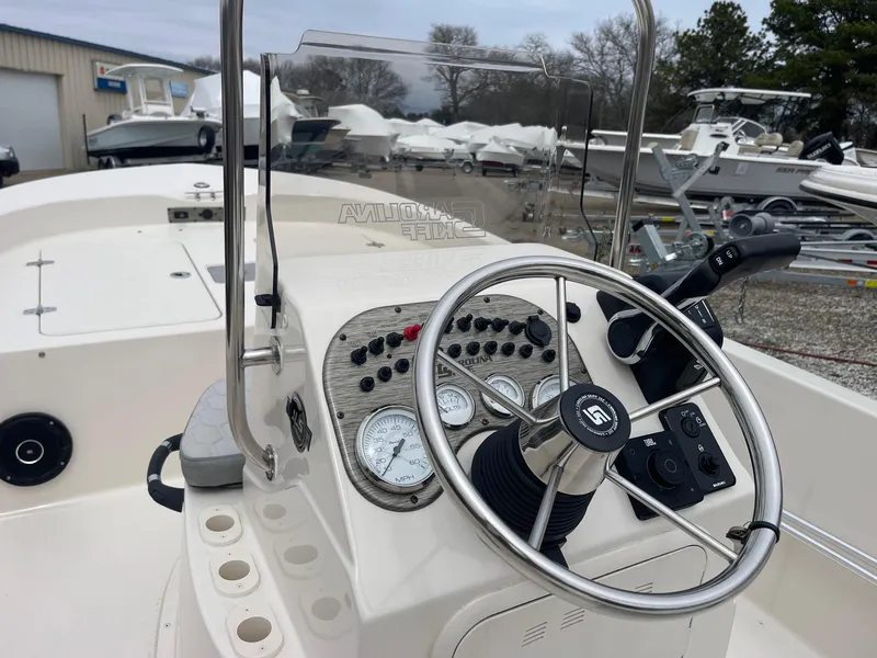 Slide: The Image of 2025 Carolina Skiff 162 JLS boat dashboard with steering wheel and control panel. - 6