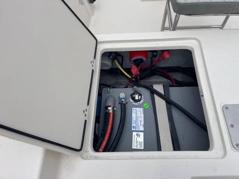 Slide: The Image of 2025 Carolina Skiff 162 JLS boat compartment with wiring and battery. - 7
