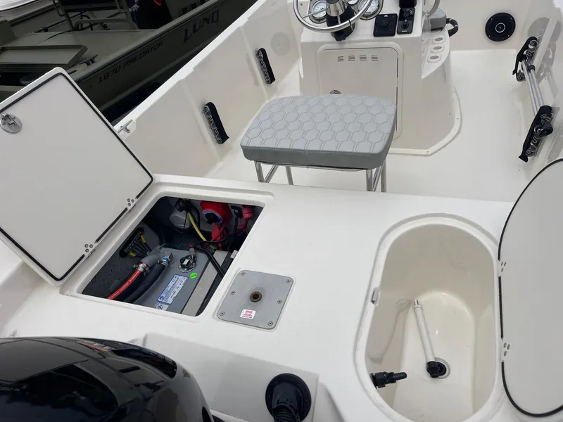 Slide: The Image of 2025 Carolina Skiff 162 JLS boat interior with open storage compartments and seating. - 8