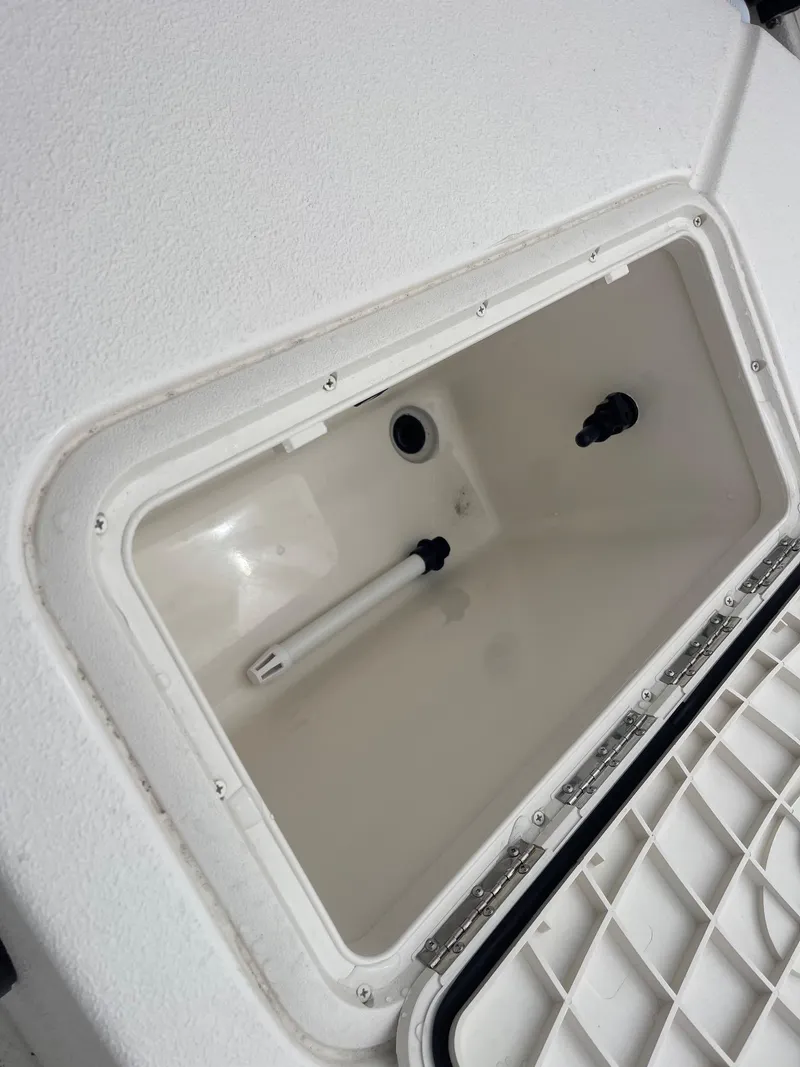 Slide: The Image of 2025 Carolina Skiff EV218 Sea Skiff storage compartment, open lid, white interior. - 14