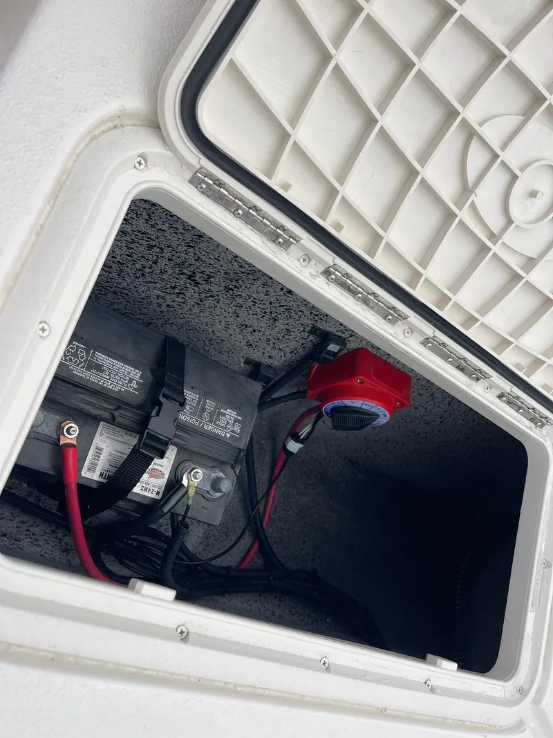 Slide: The Image of Battery compartment of 2025 Carolina Skiff EV218 Sea Skiff, featuring wiring and switch. - 15