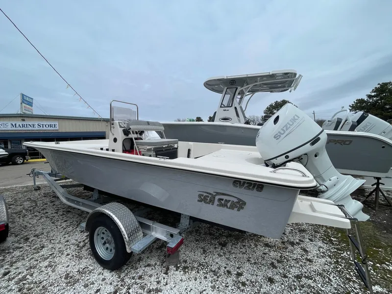 Slide: The Image of 2025 Carolina Skiff EV218 Sea Skiff on trailer, displayed at a marine store. - 4