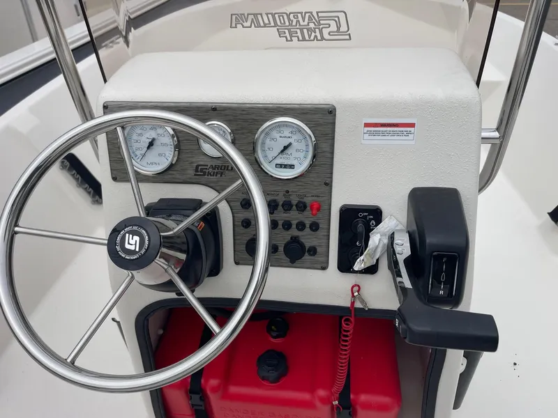 Slide: The Image of 2025 Carolina Skiff EV218 Sea Skiff dashboard with steering wheel and control panel. - 7