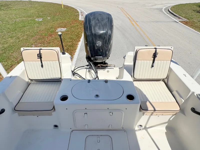 Slide: The Image of 2020 Carolina Skiff 19 LS boat interior with seating and motor, parked on a road. - 17