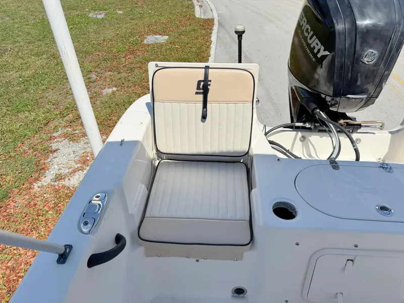Slide: The Image of 2020 Carolina Skiff 19 LS boat seat and Mercury outboard motor, docked on a sunny day. - 19
