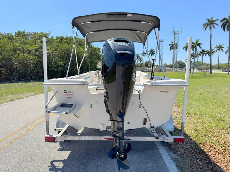 Slide: The Image of 2020 Carolina Skiff 19 LS boat on trailer, parked on road with palm trees. - 3