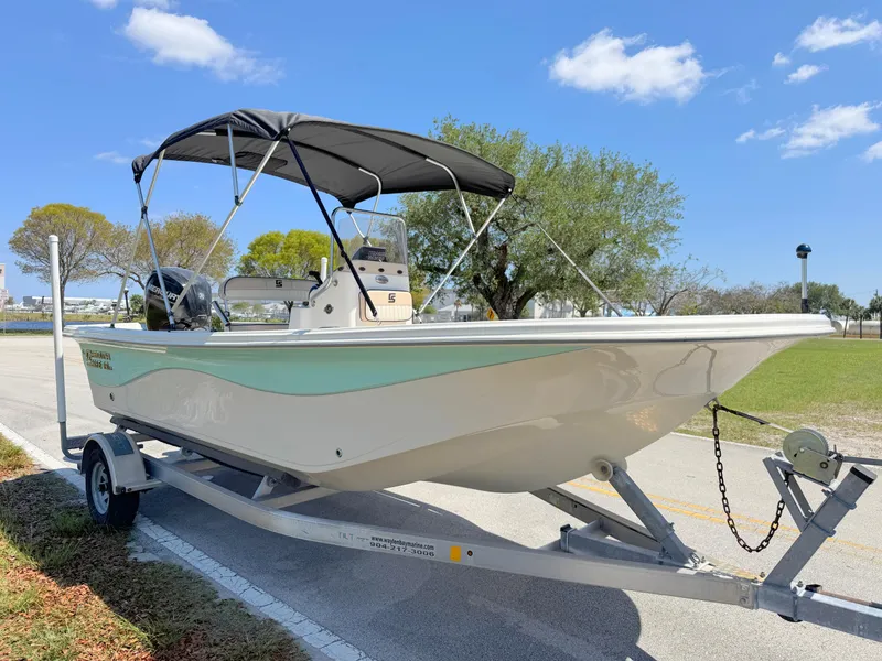 Slide: The Image of 2020 Carolina Skiff 19 LS boat on trailer, parked outdoors under a clear blue sky. - 6