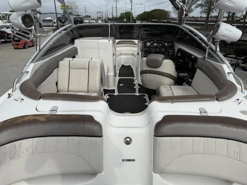 Slide: The Image of 2007 Yamaha Boats AR 230 interior with seating and dashboard, featuring white and brown upholstery. - 12