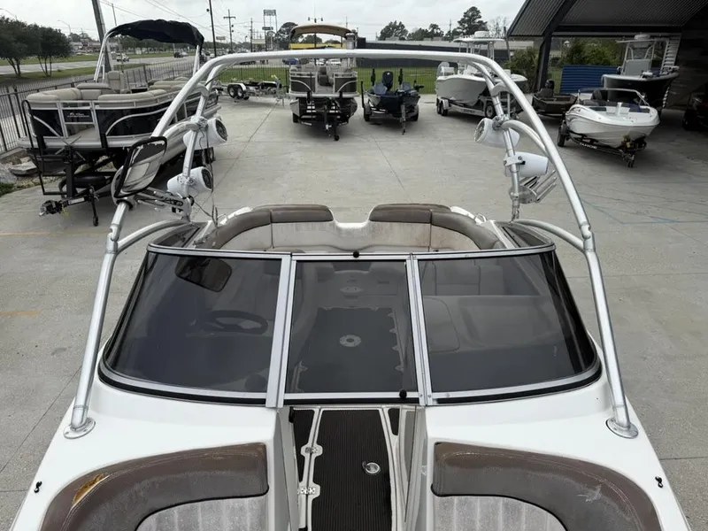 Slide: The Image of 2007 Yamaha Boats AR 230 with sleek design, parked among other boats in a marina. - 13