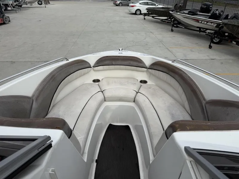 Slide: The Image of 2007 Yamaha Boats AR 230 interior with cushioned seating and cup holders, parked in a lot. - 14