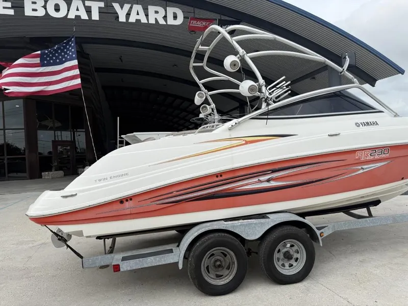 Slide: The Image of 2007 Yamaha AR 230 boat on trailer at dealership, American flag in background. - 3