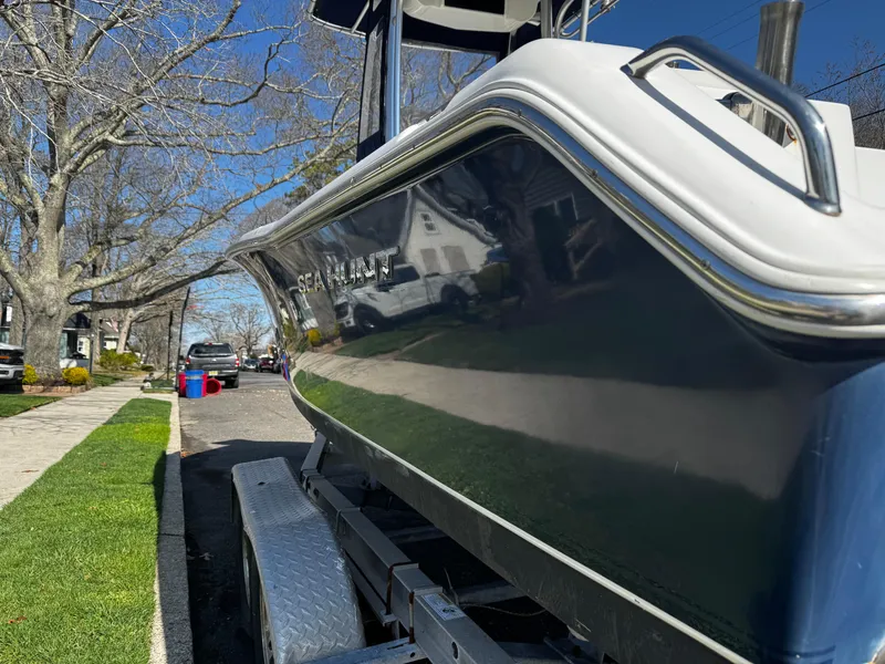 Slide: The Image of 2012 Sea Hunt Triton 210 boat on trailer, parked on a suburban street. - 3