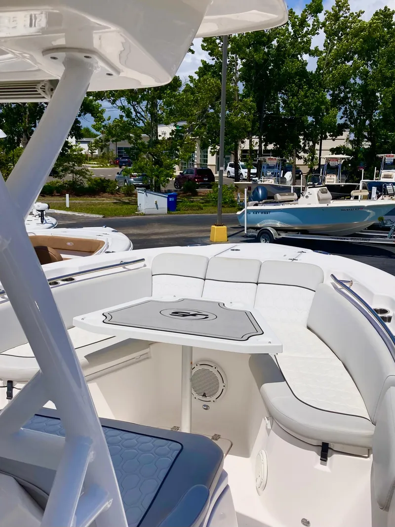 Slide: The Image of 2020 Sea Fox 288 Commander boat interior with seating and table, parked outdoors. - 14