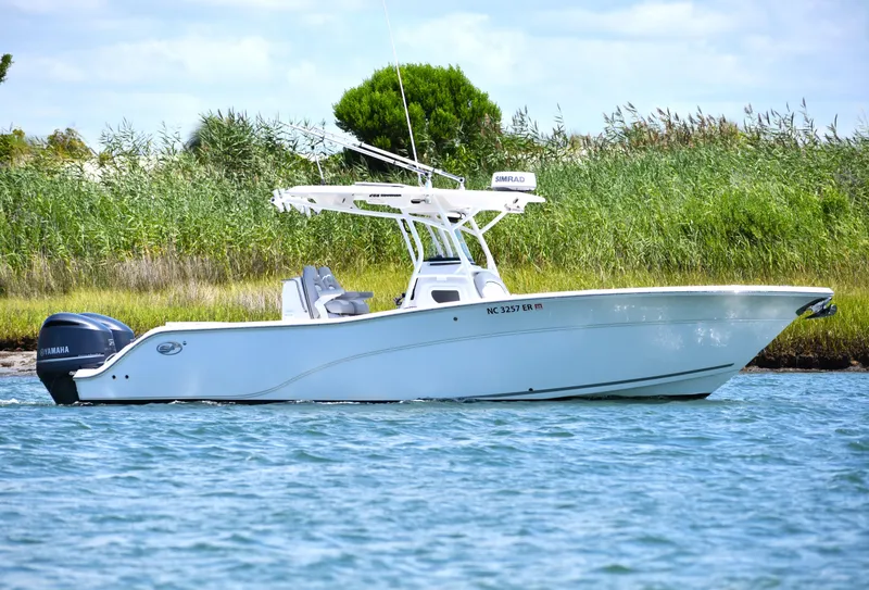 Slide: The Image of 2020 Sea Fox 288 Commander boat on water, surrounded by lush greenery. - 2