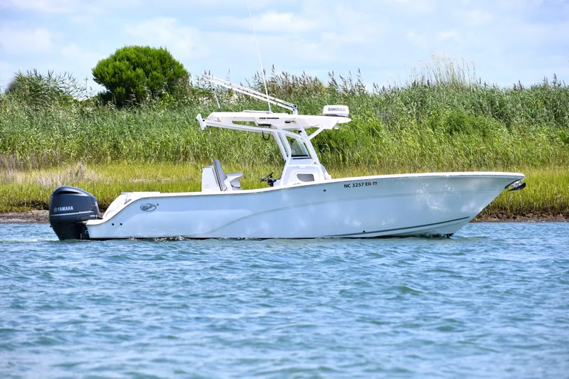 Slide: The Image of 2020 Sea Fox 288 Commander boat on water near grassy shoreline. - 3
