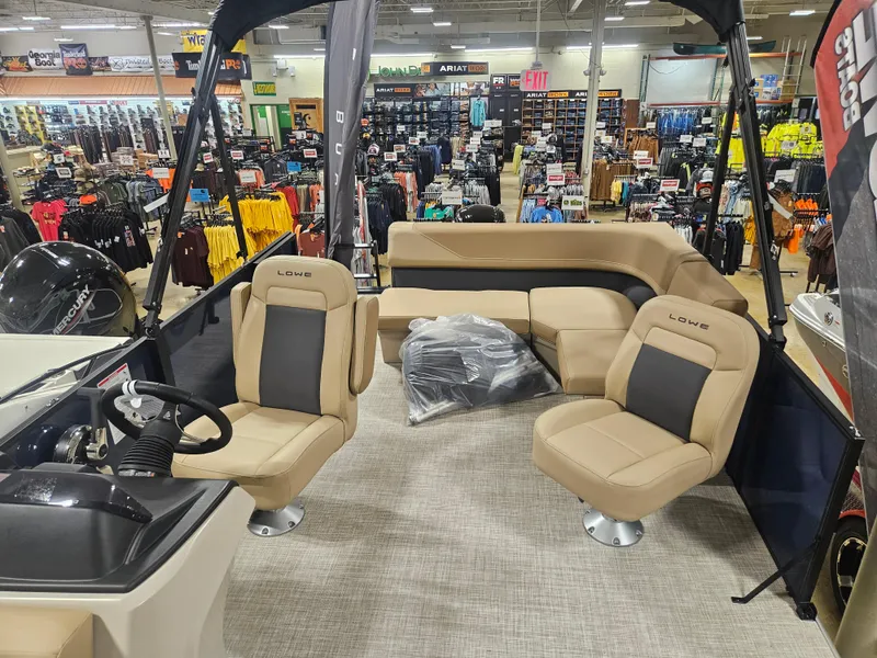 Slide: The Image of 2025 Lowe LS210 boat interior displayed in a store, featuring beige seating and steering console. - 4