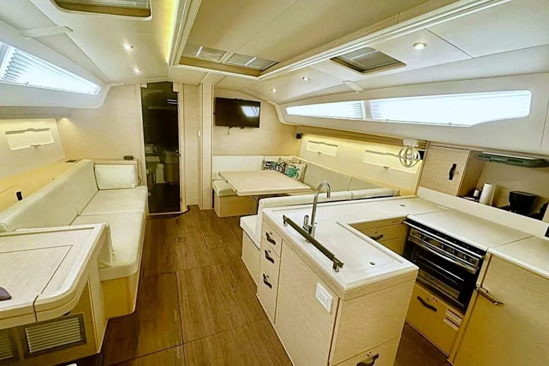 Slide: The Image of Luxurious interior of 2017 Jeanneau Sun Odyssey 51 yacht with modern kitchen and seating area. - 2