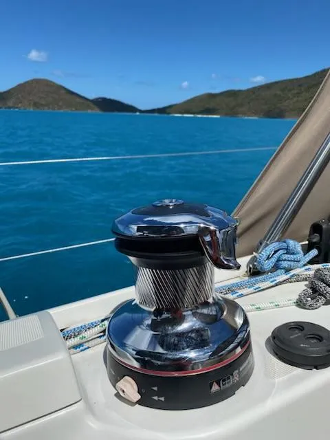 Slide: The Image of Sailing winch on Jeanneau Sun Odyssey 51, 2017, with ocean and hills in background. - 20