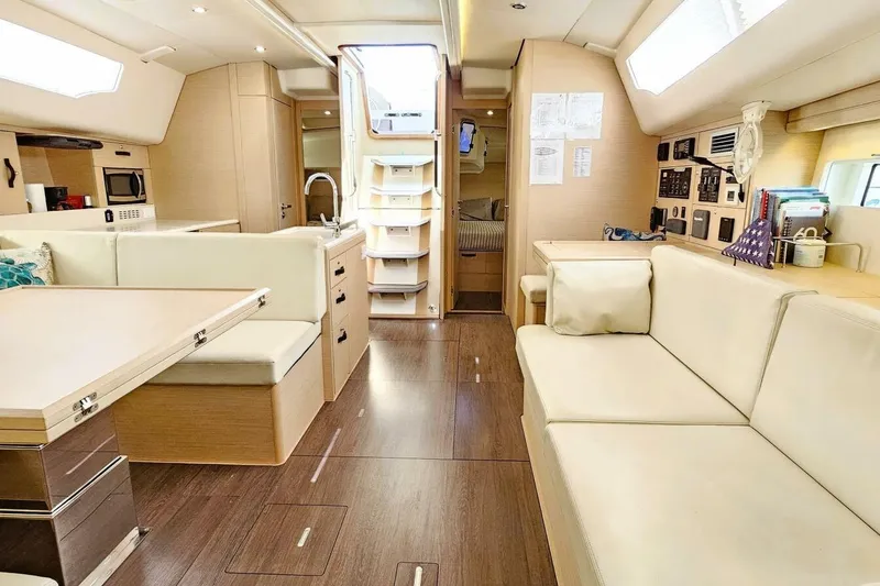 Slide: The Image of Interior of 2017 Jeanneau Sun Odyssey 51 yacht, featuring modern seating and kitchen area. - 3