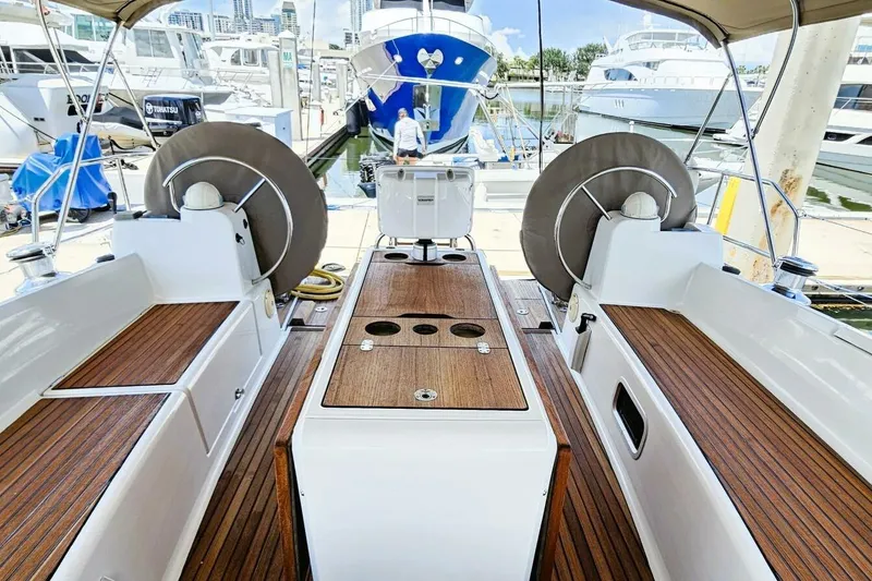 Slide: The Image of 2017 Jeanneau Sun Odyssey 51 yacht cockpit with wooden deck and dual steering wheels. - 42