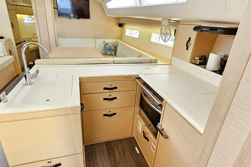 Slide: The Image of Modern kitchen interior of 2017 Jeanneau Sun Odyssey 51 yacht, featuring sleek cabinetry and appliances. - 9