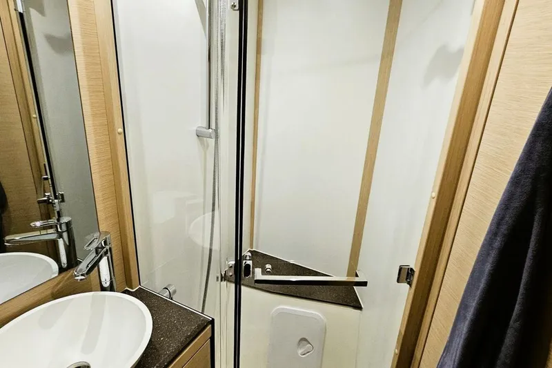 Slide: The Image of Modern bathroom in 2017 Jeanneau Sun Odyssey 51 yacht with sleek fixtures and shower. - 13