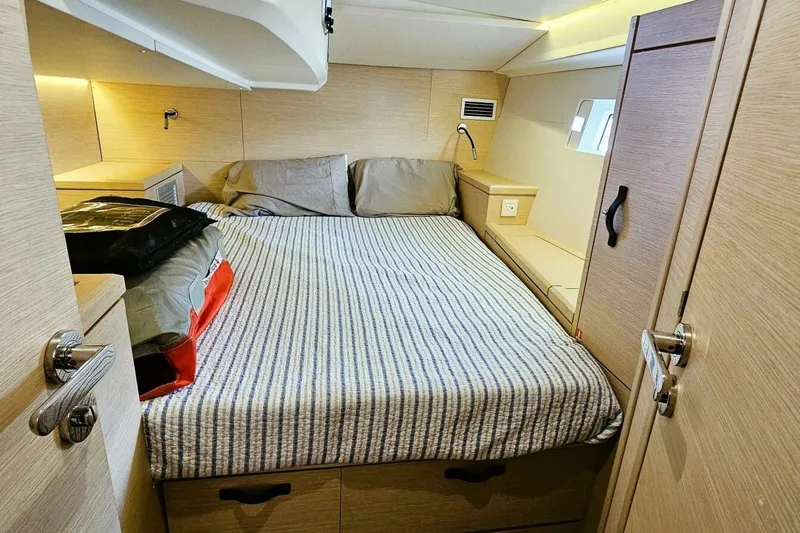 Slide: The Image of Cozy cabin interior of 2017 Jeanneau Sun Odyssey 51 yacht with striped bedding. - 14