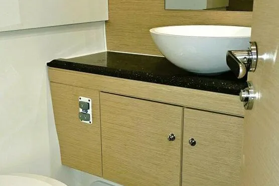 Slide: The Image of Modern bathroom interior of 2017 Jeanneau Sun Odyssey 51 yacht with vessel sink and wood cabinetry. - 15