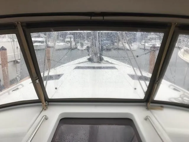Slide: The Image of 2017 Jeanneau Sun Odyssey 51 yacht cockpit view through rain-speckled windows at marina. - 30