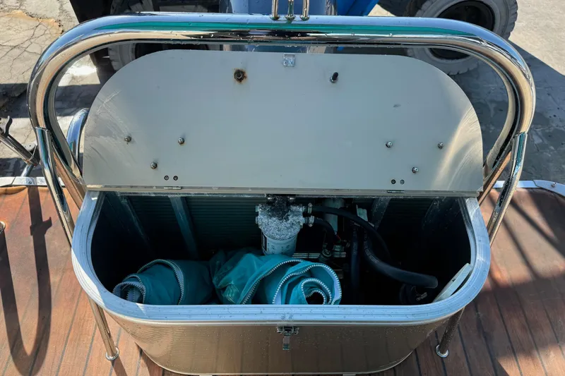 Slide: The Image of Open storage compartment on 2016 Avalon 2585 QL boat with hoses inside. - 10