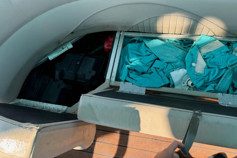 Slide: The Image of Storage compartment in a 2016 Avalon 2585 QL boat with teal fabric and equipment. - 11