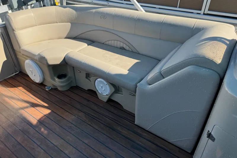 Slide: The Image of 2016 Avalon 2585 QL boat seating with speakers on wooden deck. - 16