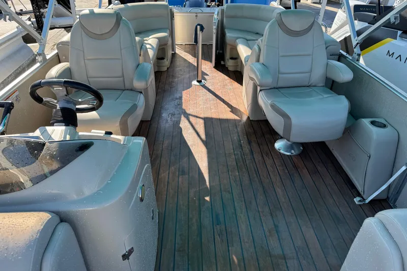 Slide: The Image of Interior of 2016 Avalon 2585 QL pontoon boat with plush seating and wooden flooring. - 2