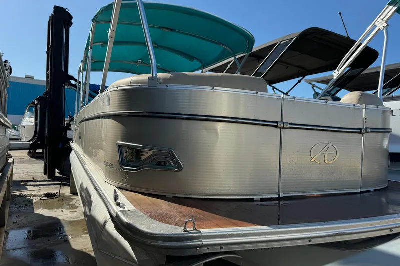 Slide: The Image of 2016 Avalon 2585 QL pontoon boat with teal canopy, docked in marina. - 20