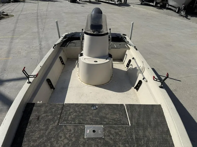Slide: The Image of 2009 Xpress H20 BAY boat interior with console and rod holders, parked on concrete. - 10