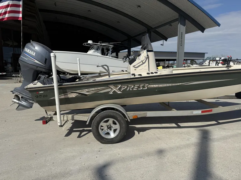 Slide: The Image of 2009 Xpress H20 BAY boat on trailer with Yamaha outboard motor, parked outdoors. - 2