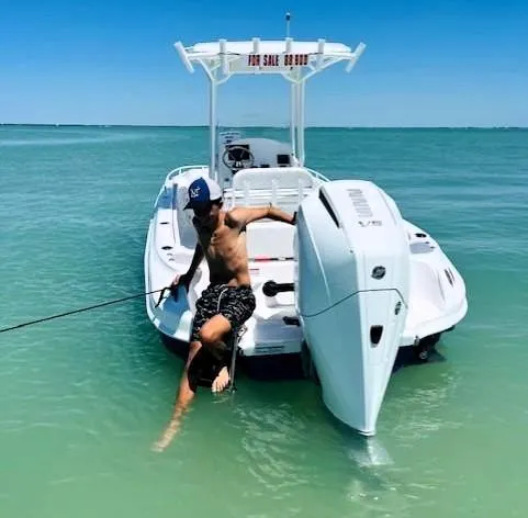 Slide: The Image of 2025 Glasstream 240 CCX boat in clear blue water, person relaxing on the stern. - 5
